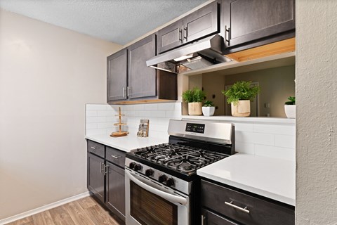 a kitchen with black cabinets and white countertops